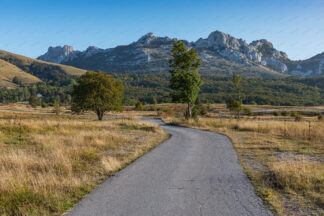 Road in Baske Ostarije. Dabarski kukovi in front (Kiza peak) in  Lika.