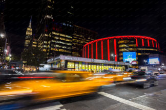 Madison Square Garden at night with traffic lights in New York City