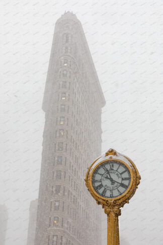 Flatiron building and golden clock at snow storm in New York City