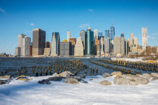 Manhattan downtown over wooden pillars at sunny day in winter, New York City