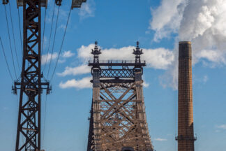 View to Queensboro bridge with steaming chimney in New York City