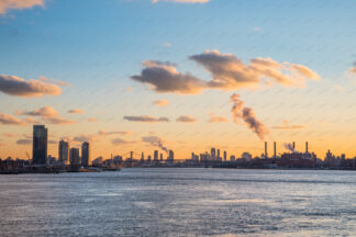 New York City skyline over East river at sunset. Manhattan Bridge in distance