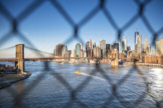 Brooklyn Bridge and Manhattan Downtown trough the wire fence, New York City