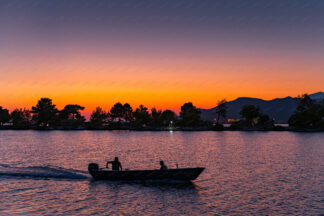 River sunset. Motor boat floating on Neretva river at sunset